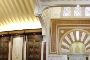 Detalle del interior: techo de lamas doradas, puertas de madera taraceada y el arco del mihrab