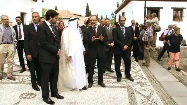 Sheij Sultan bin Muhammad Al-Qasimi, in white robes, walks with officials along a cobbled Albaicin street