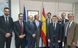 Nueve hombres con traje posan en un despacho junto a las banderas de España y de la Unión Europea