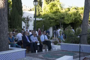 Público sentado en el jardín de la Mezquita junto a la fuente alicatada y las alfombras