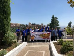 Delegación malaya con una pancarta de su viaje educativo posando con la Alhambra al fondo