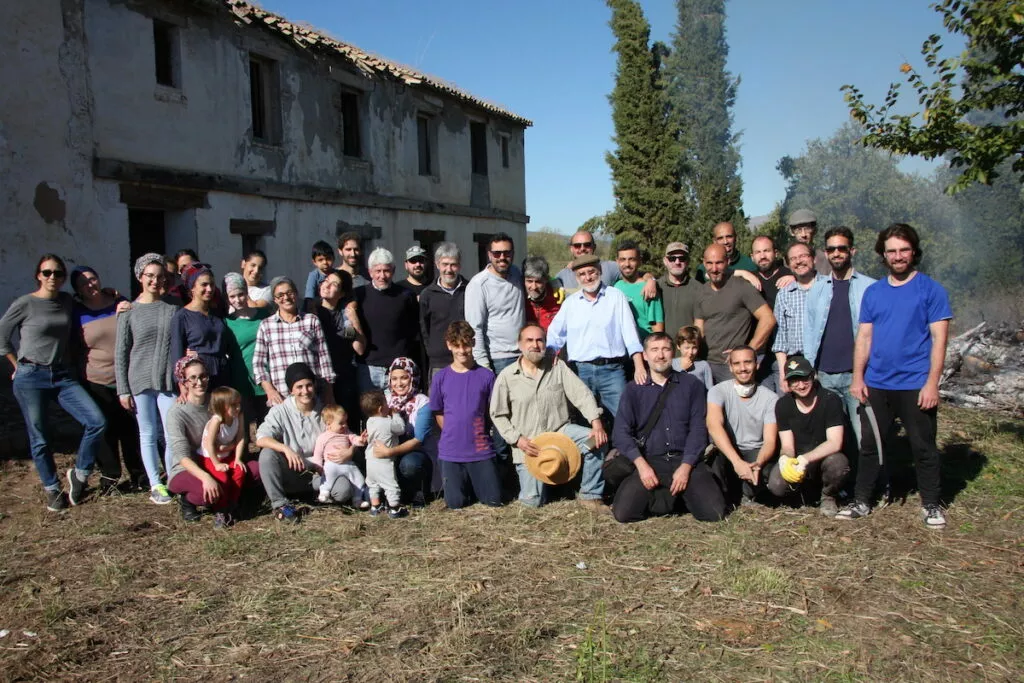 Voluntarios posando ante el caserío en ruinas de la futura Madrasa tras la jornada de limpieza