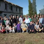 Voluntarios posando ante el caserío en ruinas de la futura Madrasa tras la jornada de limpieza