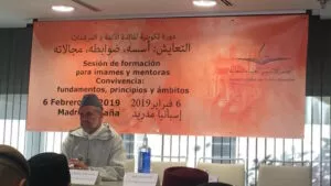 Ponente con chilaba bajo la pancarta de la sesión de formación para imames y mentoras, Madrid 2019