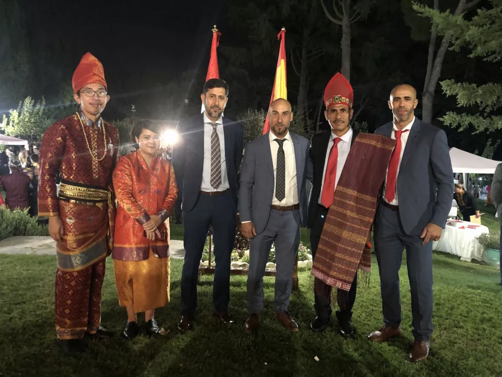 Seis invitados posan ante las banderas de Indonesia y España durante la recepción nocturna