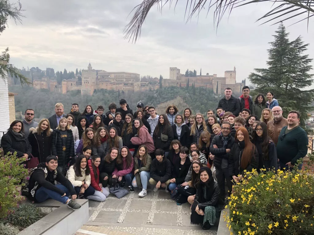 Grupo grande de estudiantes posando en el mirador con la Alhambra al fondo