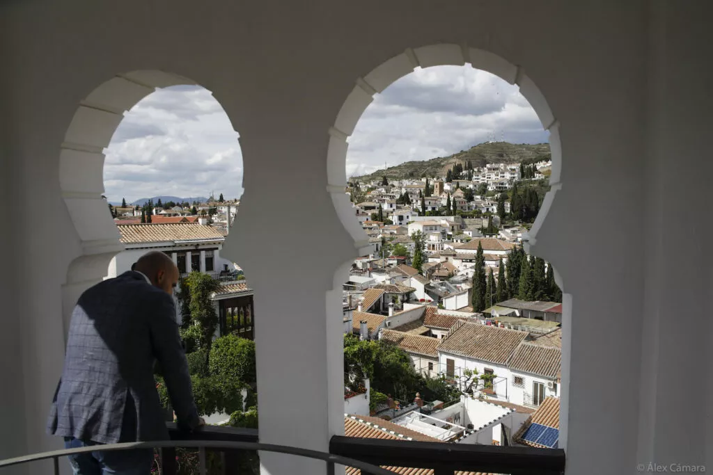 Un visitante contempla el Albaicín desde los arcos del mirador de la mezquita