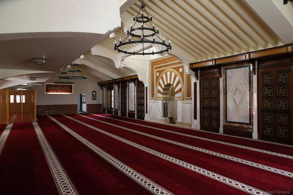 La sala de oración desde el lado opuesto, con el mihrab al fondo y las puertas de madera tallada