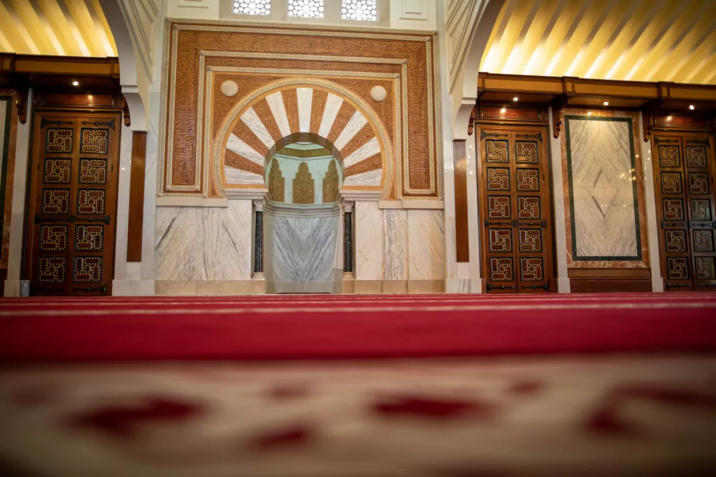 El mihrab visto a ras de suelo, con las puertas de madera taraceada a ambos lados