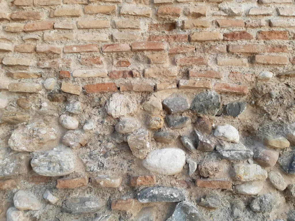 Detalle del muro histórico de mampostería y ladrillo junto a la mezquita