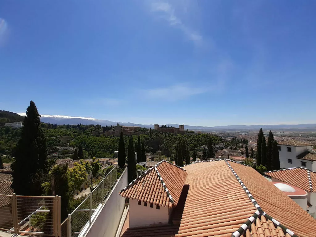 Vista de la Alhambra y Sierra Nevada desde la azotea de la mezquita, sobre los tejados de teja