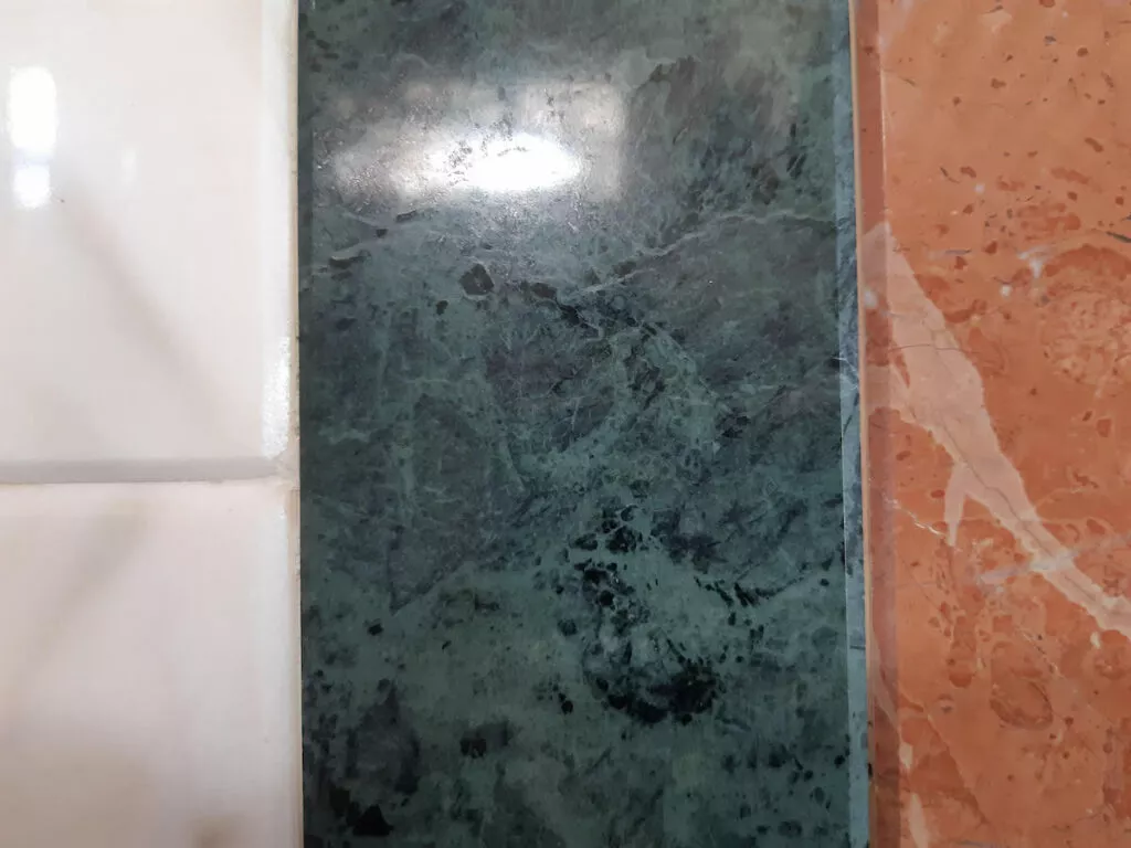 Detalle del zócalo de mármol blanco, verde y rojo del interior de la mezquita