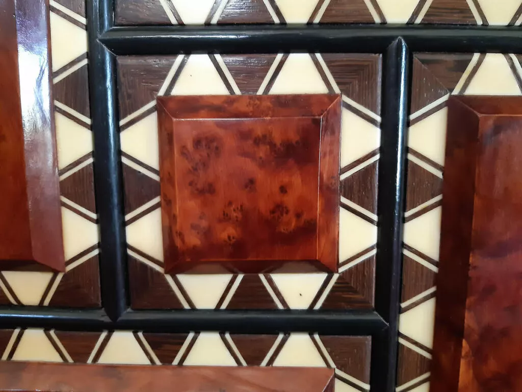 Detalle de una puerta de taracea con marquetería geométrica en maderas claras y oscuras