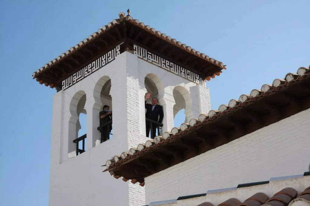Dos personas saludan desde el mirador del alminar de la mezquita