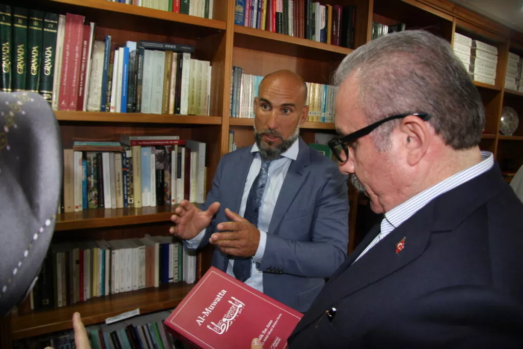 Un anfitrión muestra un ejemplar de Al-Muwatta a un visitante en la biblioteca de la mezquita