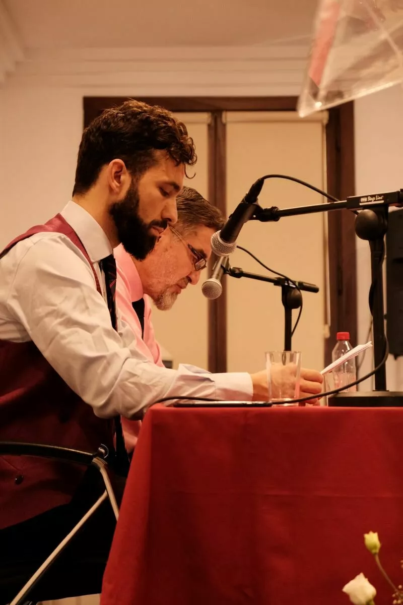 Dos participantes leen un texto ante los micrófonos durante el acto