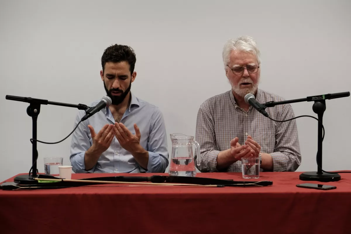 Dos ponentes hacen la súplica con las manos abiertas ante los micrófonos de la mesa