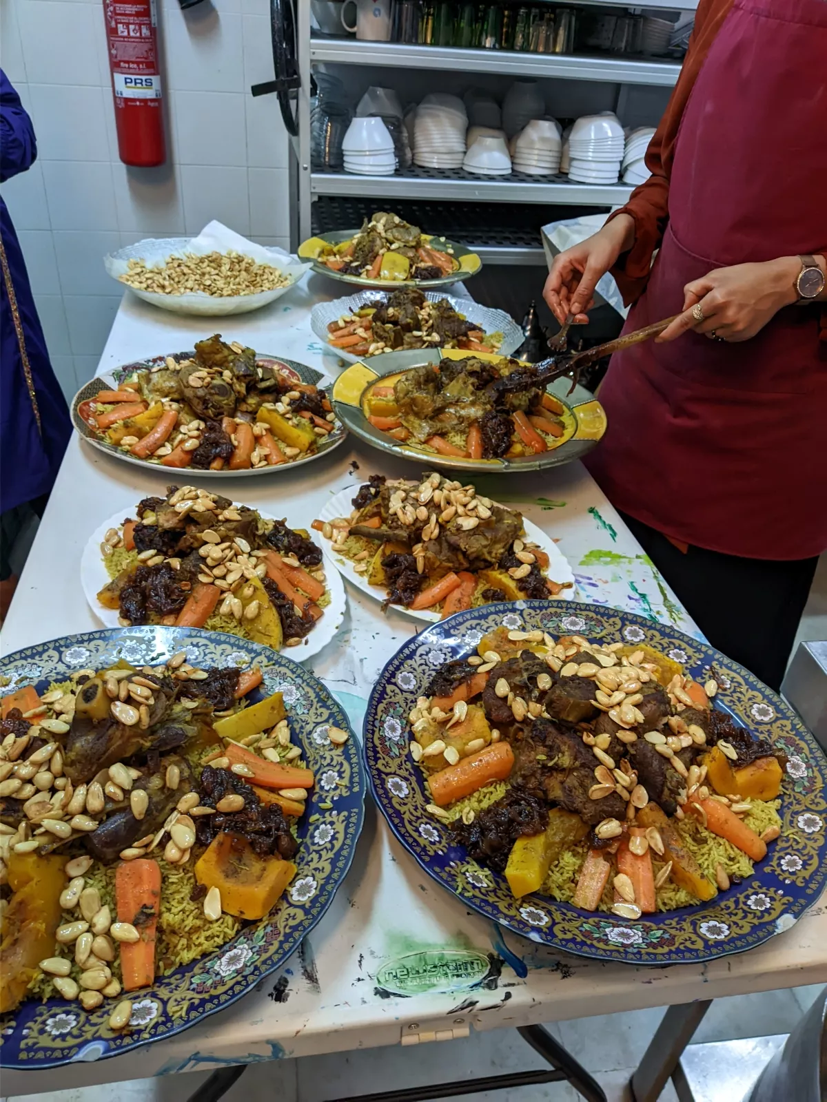 Fuentes de cordero con arroz, zanahoria y almendras preparadas en la cocina para la comida del encuentro