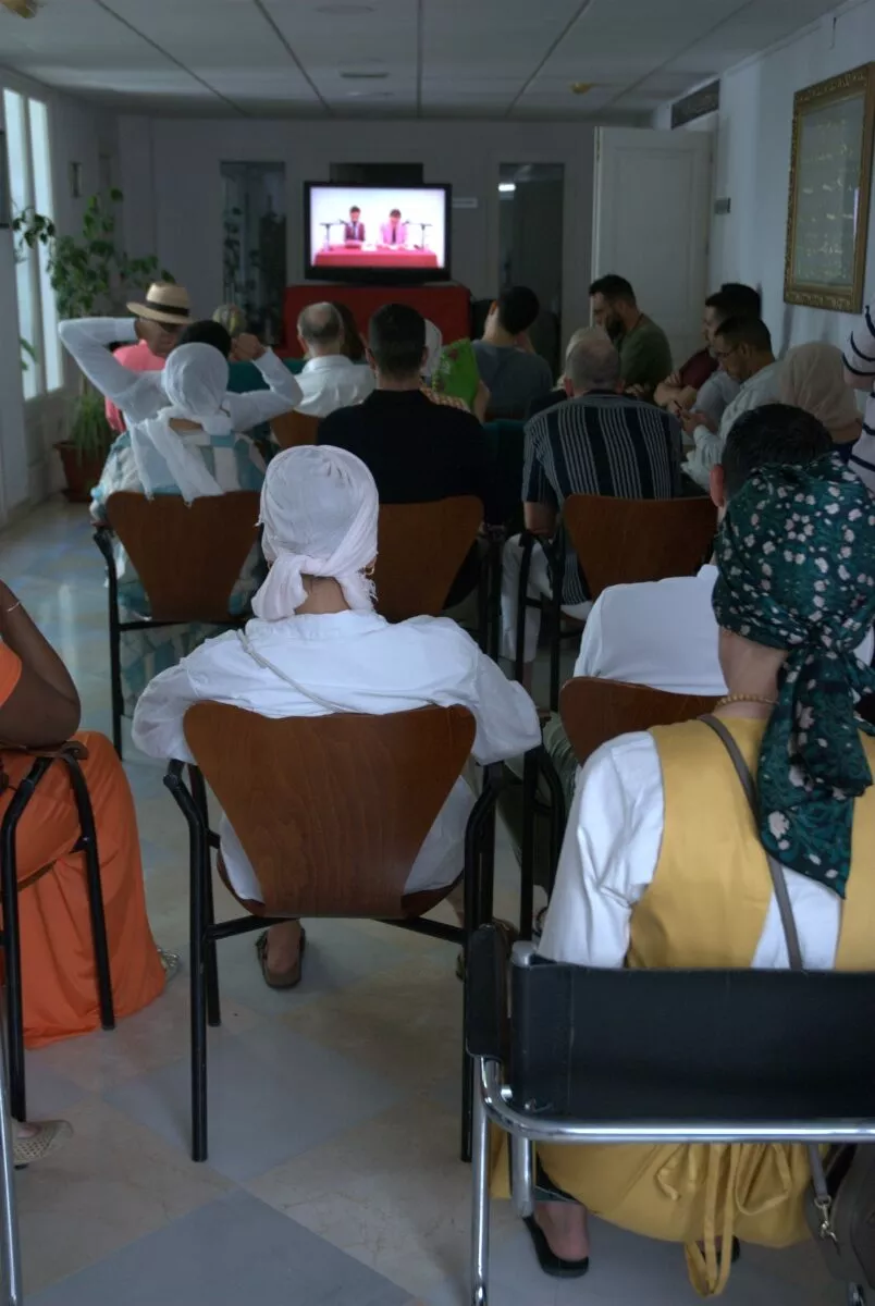 Asistentes siguen la sesión desde una sala contigua a través de una pantalla