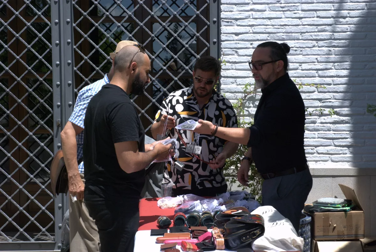 Puesto de complementos y bisutería atendido en el patio durante el mercado