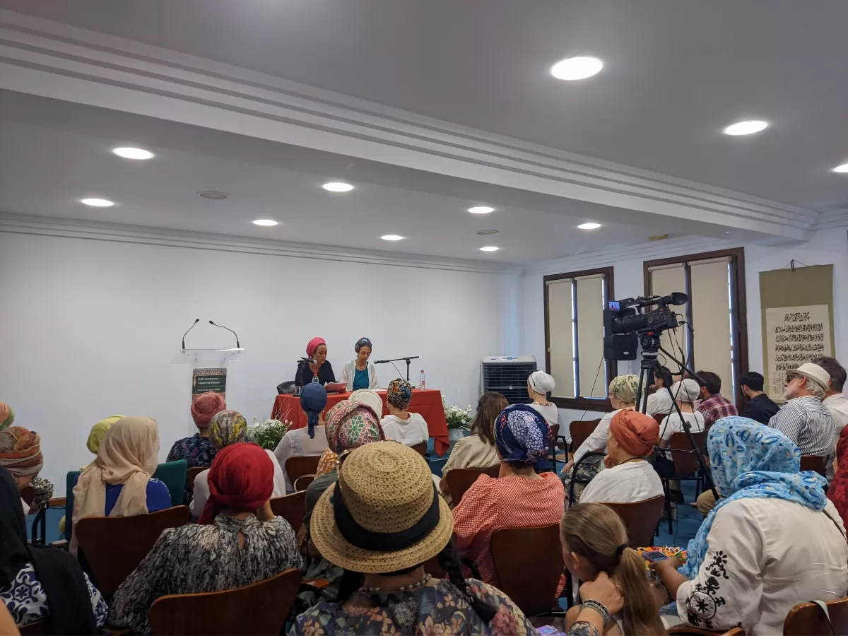 Vista general del encuentro de mujeres, con las dos ponentes en la mesa y el público sentado