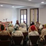Mujeres con pañuelos en la sala del Mausim Granada 2024 escuchando a las ponentes de la mesa