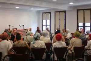 Mujeres con pañuelos en la sala del Mausim Granada 2024 escuchando a las ponentes de la mesa